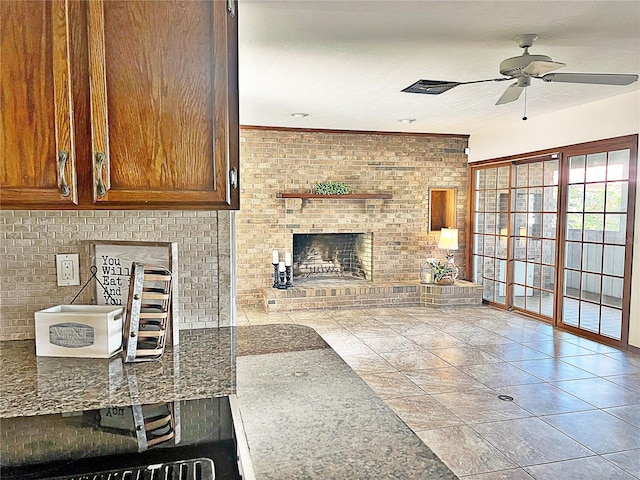 unfurnished living room featuring brick wall, a brick fireplace, a textured ceiling, and ceiling fan