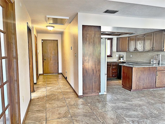 kitchen with decorative backsplash, dark brown cabinets, and a textured ceiling