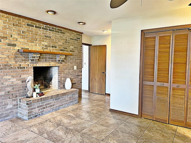 unfurnished living room featuring ceiling fan and a fireplace