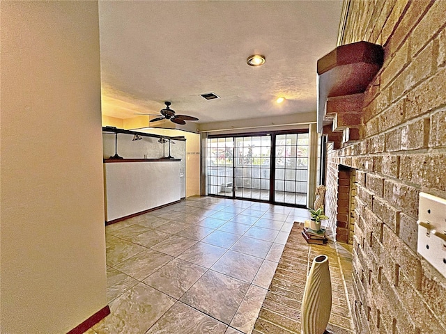 unfurnished living room featuring a textured ceiling and ceiling fan