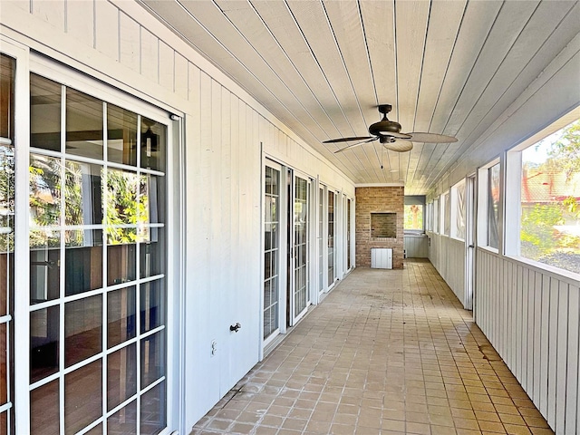 unfurnished sunroom with a wealth of natural light, wooden ceiling, and ceiling fan