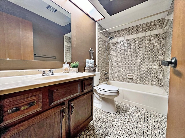 full bathroom featuring tile patterned floors, vanity, toilet, and tiled shower / bath combo