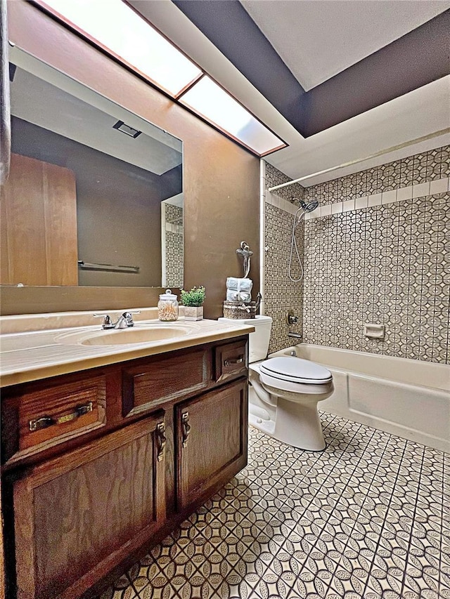 full bathroom featuring tiled shower / bath, vanity, and toilet