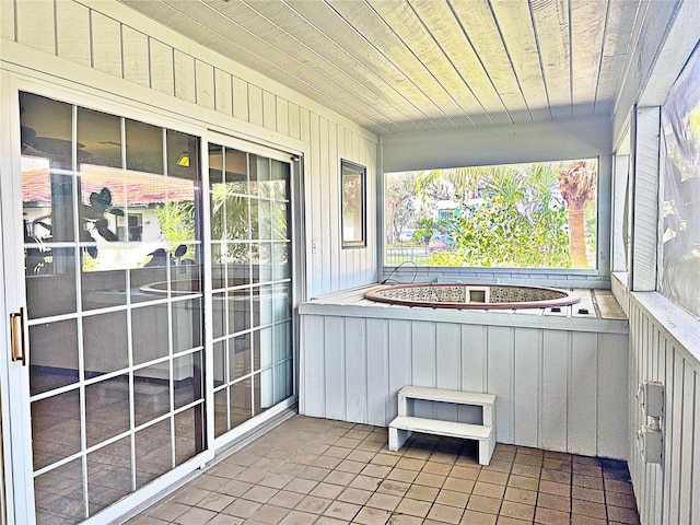 unfurnished sunroom featuring wood ceiling and a jacuzzi