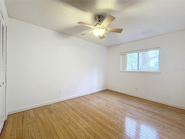 spare room featuring ceiling fan, a textured ceiling, and light hardwood / wood-style flooring