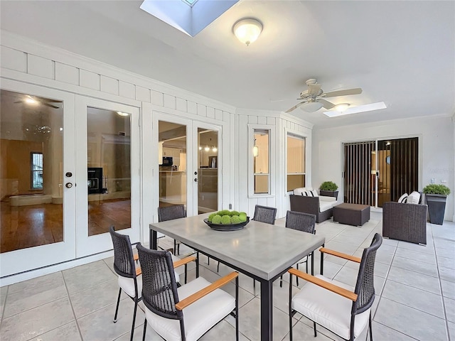 sunroom / solarium with a skylight, ceiling fan, and french doors