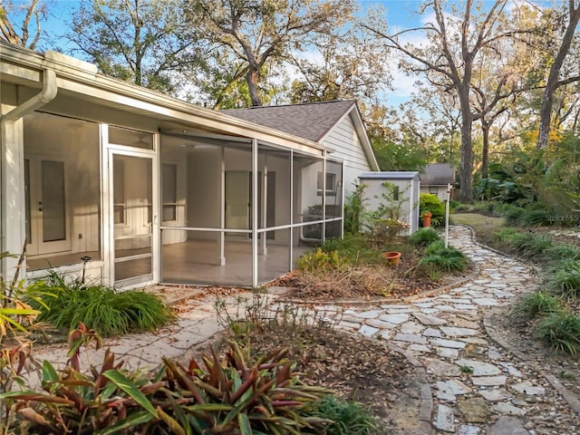 view of property exterior with a sunroom