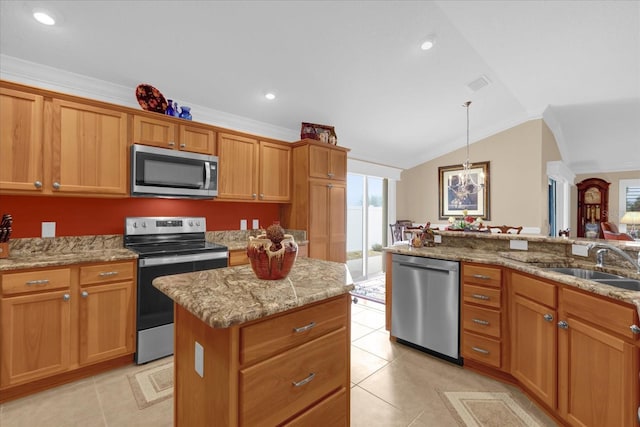 kitchen with lofted ceiling, sink, stainless steel appliances, a center island, and decorative light fixtures