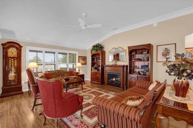 living room with light hardwood / wood-style flooring, vaulted ceiling, and ornamental molding