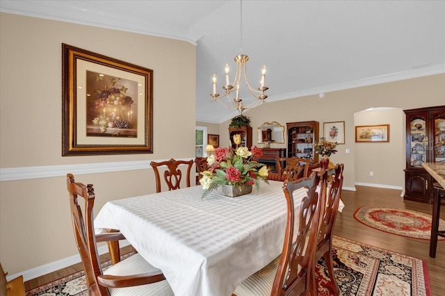 dining room with hardwood / wood-style flooring, ornamental molding, and an inviting chandelier