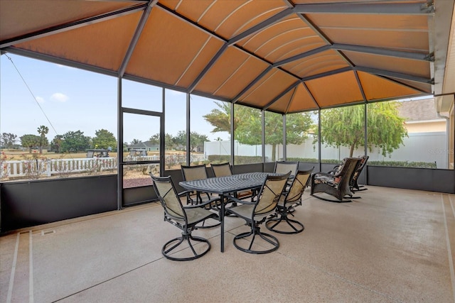 unfurnished sunroom featuring vaulted ceiling