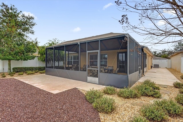 back of property with a lanai and a patio area