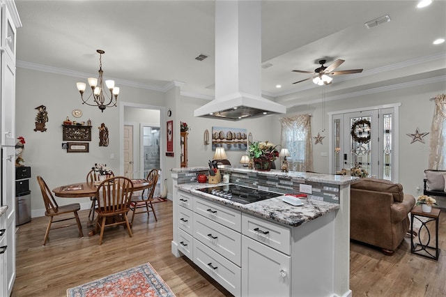 kitchen with white cabinetry, island exhaust hood, black electric stovetop, light stone counters, and light wood-type flooring