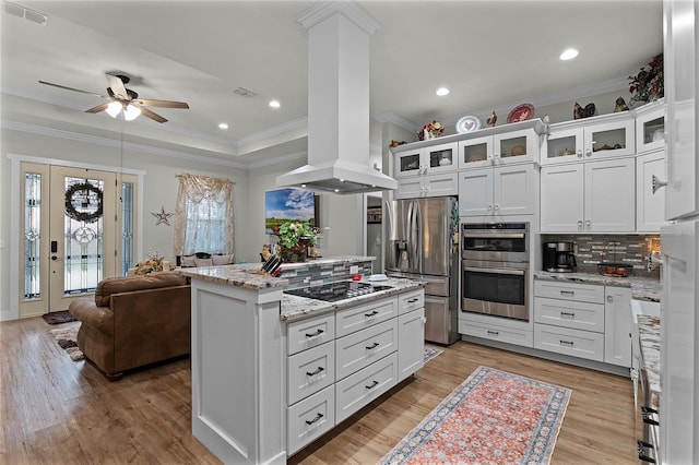 kitchen featuring white cabinets, island exhaust hood, a center island, light stone counters, and stainless steel appliances