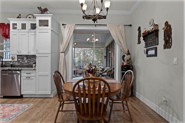 dining room with an inviting chandelier, crown molding, light hardwood / wood-style flooring, and plenty of natural light