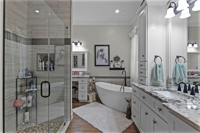 bathroom with vanity, crown molding, wood-type flooring, and shower with separate bathtub