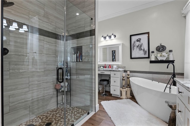 bathroom featuring wood-type flooring, shower with separate bathtub, tile walls, ornamental molding, and vanity