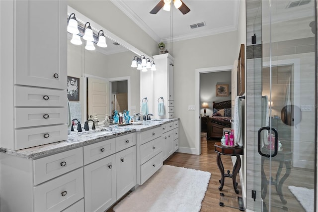 bathroom featuring hardwood / wood-style flooring, crown molding, vanity, and ceiling fan