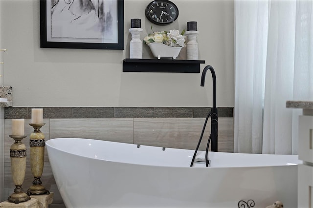 bathroom with sink, tile walls, and a tub to relax in