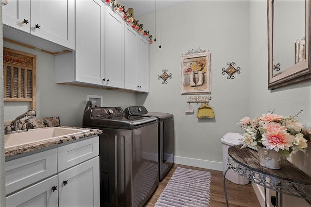 washroom featuring cabinets, separate washer and dryer, sink, and dark hardwood / wood-style floors