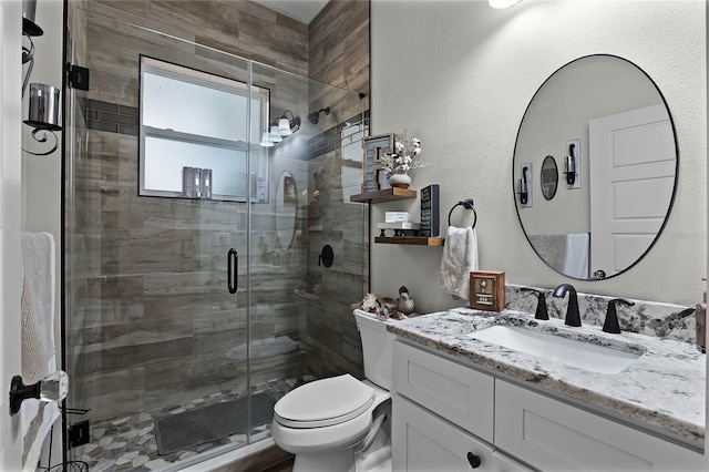 bathroom featuring vanity, toilet, and an enclosed shower