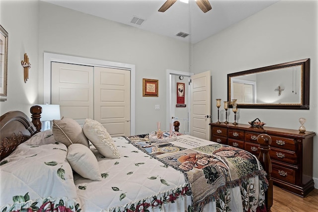 bedroom with light hardwood / wood-style flooring, ceiling fan, and a closet