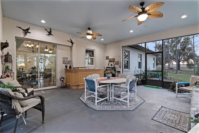 interior space featuring a healthy amount of sunlight and ceiling fan with notable chandelier