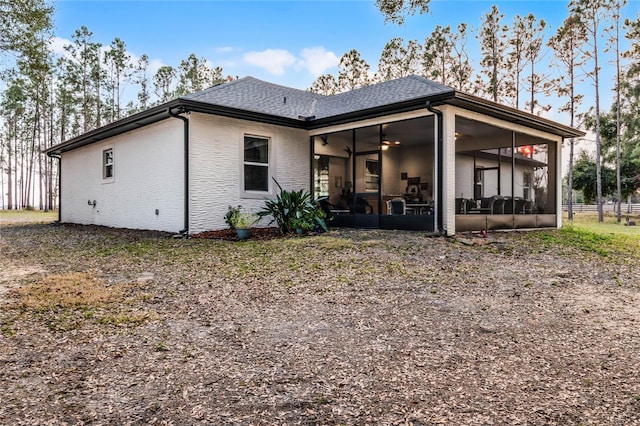 rear view of property with a sunroom and ceiling fan