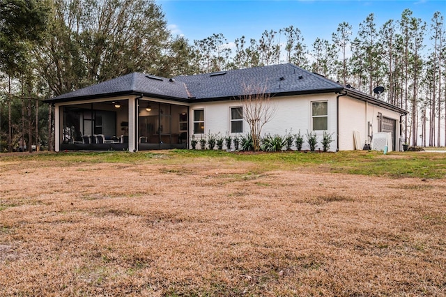 rear view of property with a yard and a sunroom