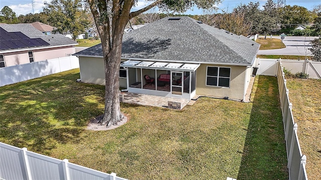 rear view of house featuring a yard and a sunroom