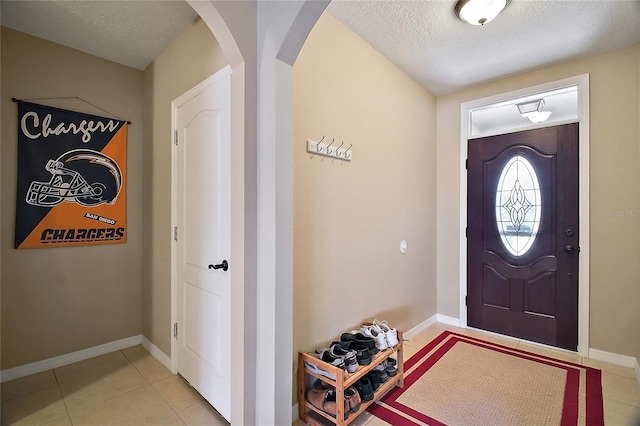 foyer with light tile patterned flooring and a textured ceiling