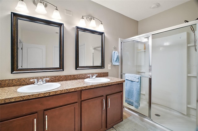 bathroom with a shower with door and vanity