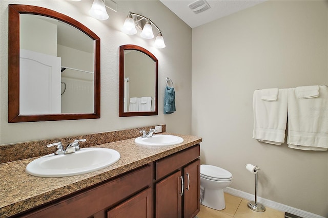 bathroom featuring tile patterned flooring, vanity, and toilet