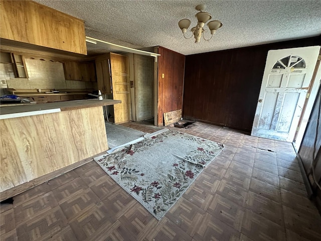 kitchen featuring backsplash, a notable chandelier, dark parquet floors, and a textured ceiling