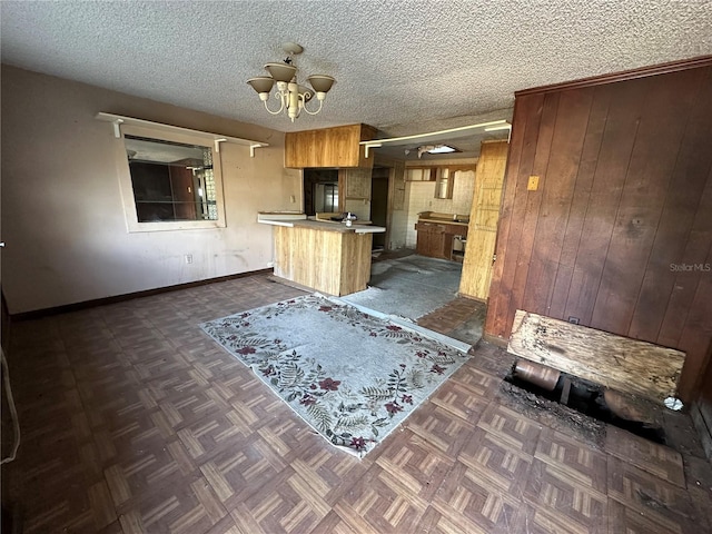 kitchen featuring a notable chandelier, dark parquet floors, kitchen peninsula, and a textured ceiling