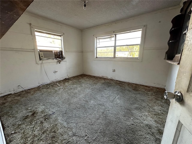 carpeted empty room featuring cooling unit and a textured ceiling