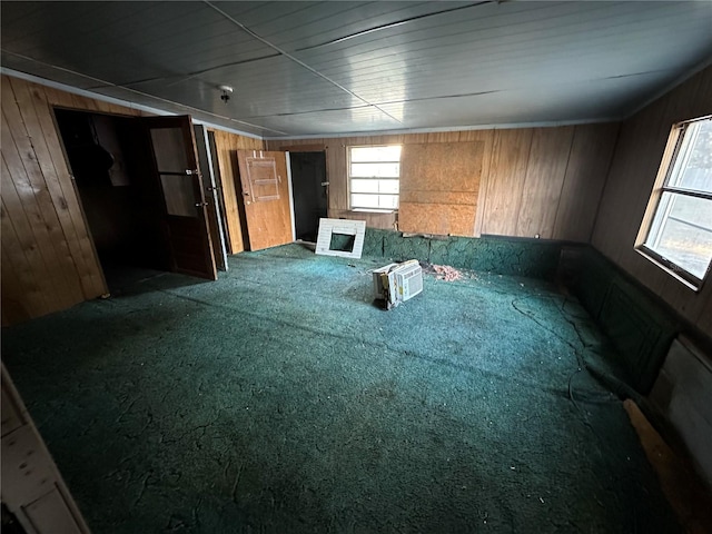 carpeted empty room with wooden walls