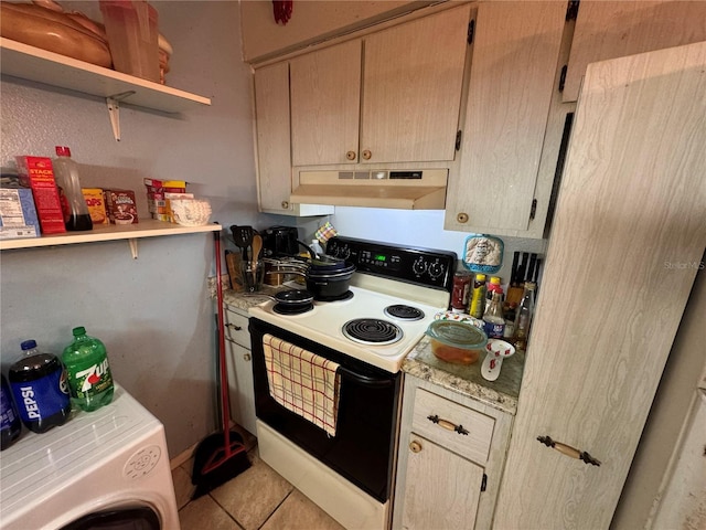 kitchen with washer / dryer, electric range oven, light tile patterned floors, and light brown cabinetry