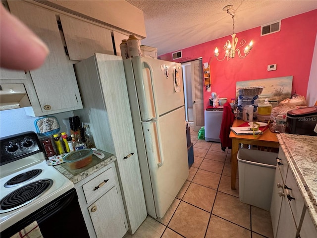 kitchen featuring light tile patterned floors, hanging light fixtures, electric range oven, white refrigerator, and a textured ceiling