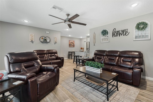 living room featuring light hardwood / wood-style flooring and ceiling fan