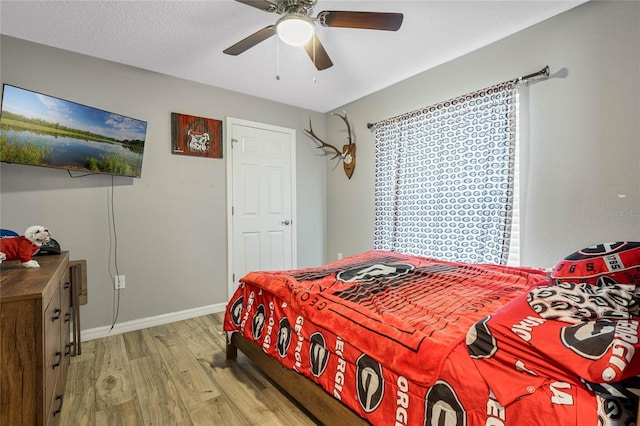 bedroom with ceiling fan, light hardwood / wood-style flooring, and a textured ceiling