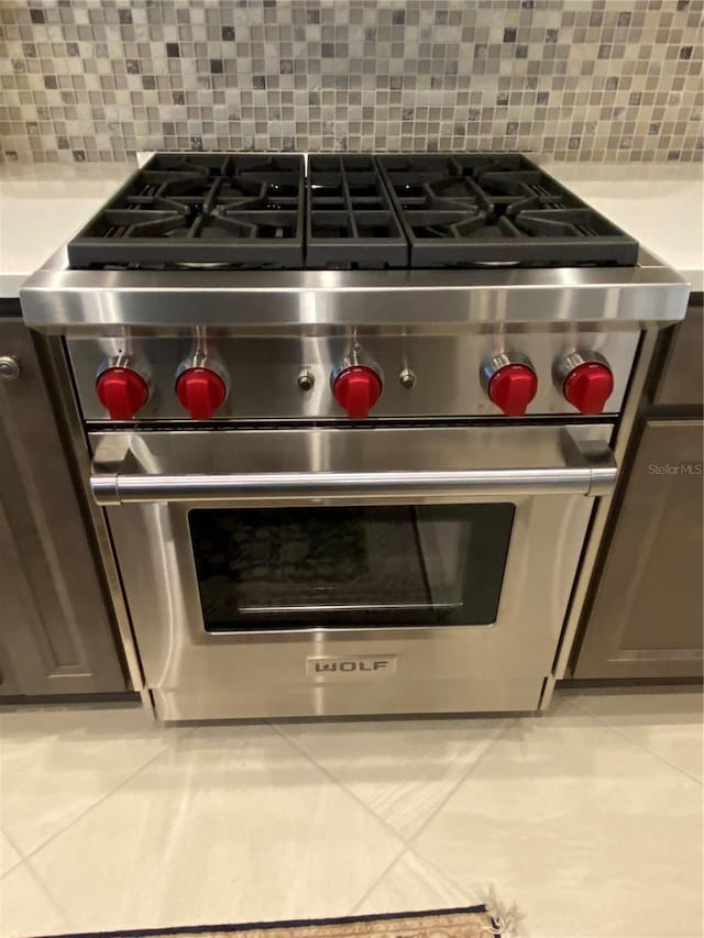 details featuring designer range and decorative backsplash