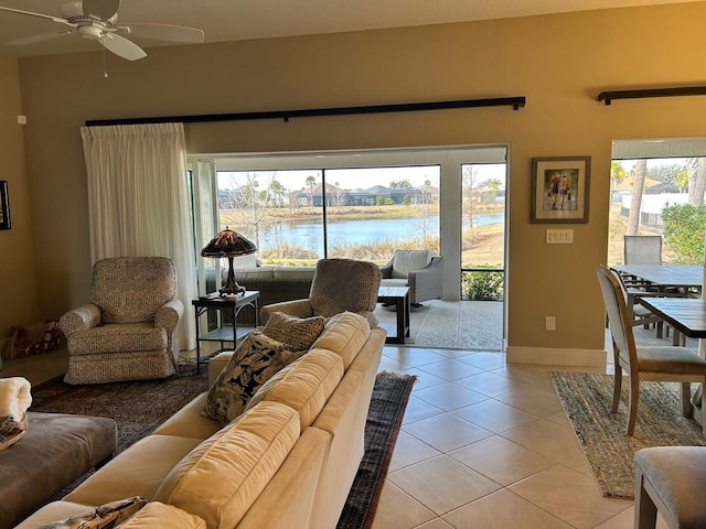 tiled living room with a water view and ceiling fan