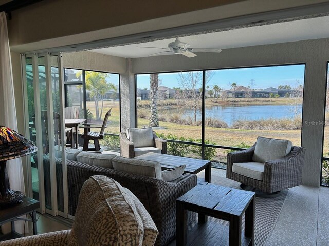 sunroom / solarium with a water view, ceiling fan, and a healthy amount of sunlight