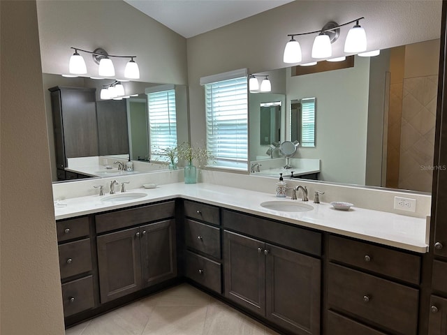 bathroom featuring vanity, vaulted ceiling, and tile patterned floors