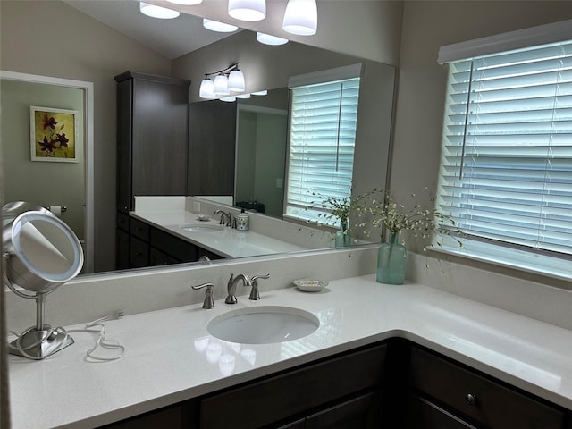 bathroom featuring vanity and lofted ceiling