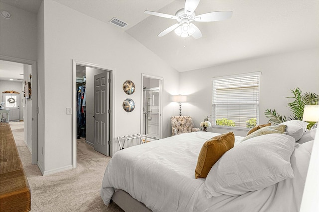 carpeted bedroom with ceiling fan, high vaulted ceiling, connected bathroom, a walk in closet, and a closet