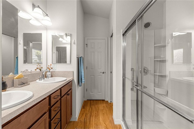 bathroom featuring an enclosed shower, vanity, and wood-type flooring