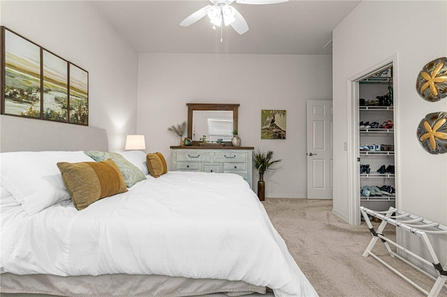 carpeted bedroom with a walk in closet, ceiling fan, and a closet