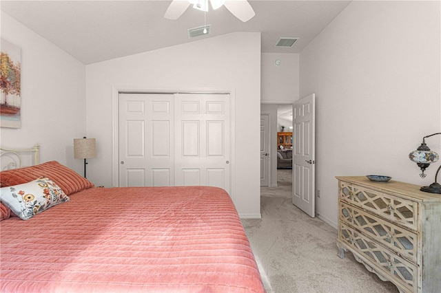 bedroom featuring ceiling fan, a closet, vaulted ceiling, and light carpet